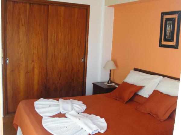 un dormitorio con cama con toallas blancas en el Aparte Familiar Antu Alen I de Villa Gesell
