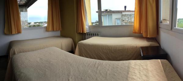 2 camas en una habitación con 2 ventanas en Ossa Mayor Apart en Las Gaviotas