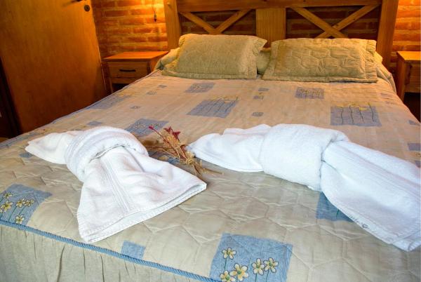 Una cama con dos toallas blancas.  en Abvai en Mar de las Pampas