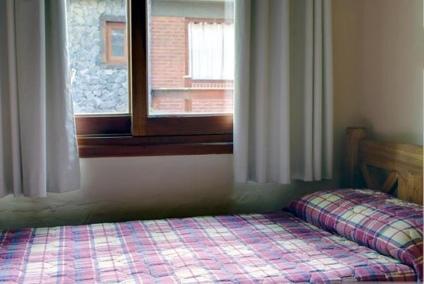 1 cama en un dormitorio con ventana en Abvai en Mar de las Pampas