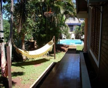 una hamaca en un patio junto a una casa en El Guembe Hostel House en Puerto Iguazú