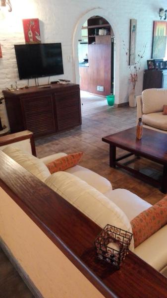 sala de estar con sofá y TV en Texas Verdes Alojamiento Familiar en Villa Gesell