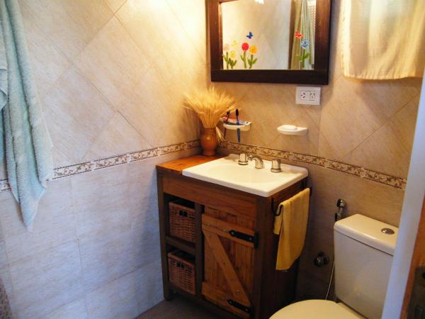 y baño con lavabo, aseo y espejo. en Cabañas Doña Itati, en Villa Carlos Paz