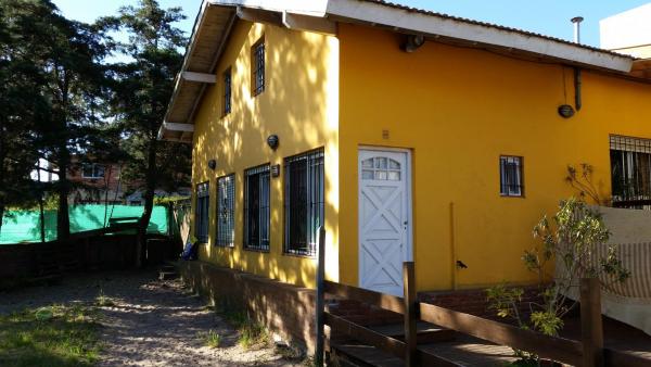 una casa amarilla con una puerta blanca en el lateral en Duplex Villa Gesell en Villa Gesell