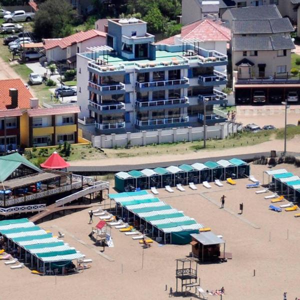 una vista aérea de una playa con sombrillas y un edificio en los Balcones Al Mar de Villa Gesell