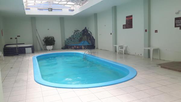 a large blue tub in a room with a tile floor at Apto Ingleses à 50mts da praia in Florianópolis