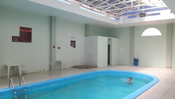 a person in a swimming pool in a building at Apto Ingleses à 50mts da praia in Florianópolis