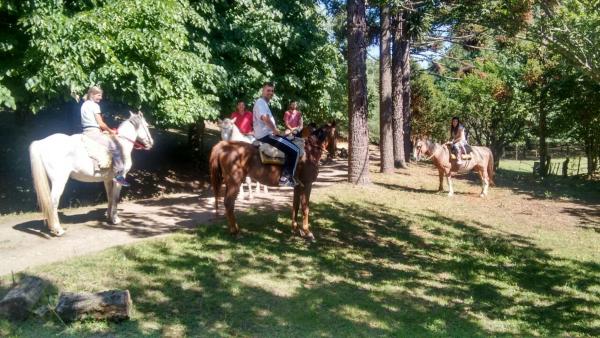 un grupo de personas montando caballos en un parque en Estancia San Miguel, en Villa Yacanto