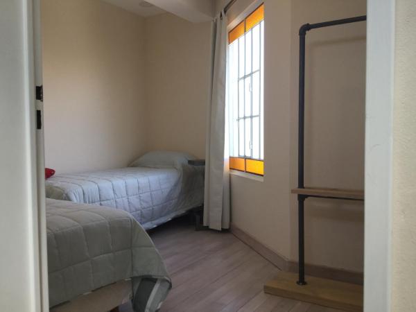 1 dormitorio con 2 camas y ventana en Wind Puerto Madryn en Puerto Madryn