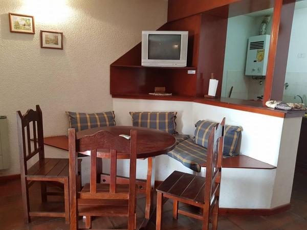 Habitación con mesa, sillas y TV. en Apart Santander, en Mina Clavero