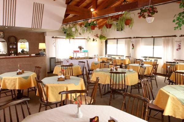 un restaurante con mesas y sillas con mantel amarillo en Hotel Massa en Villa Gesell
