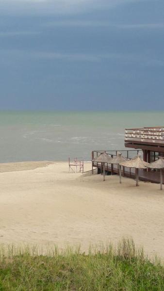 una playa con bancos sobre la arena y el océano en el hotel Vista de Villa Gesell