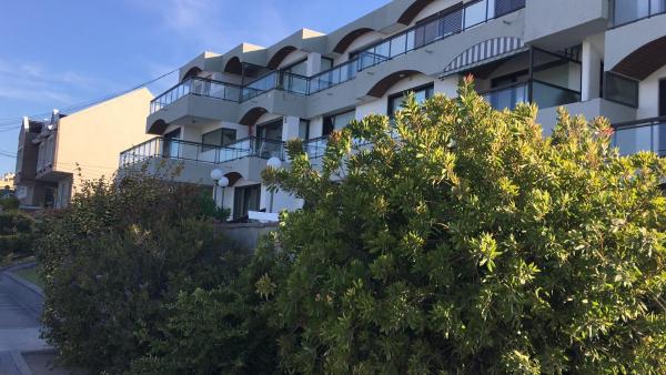 un edificio de apartamentos con árboles delante de él en Edificio Soles en Puerto Madryn