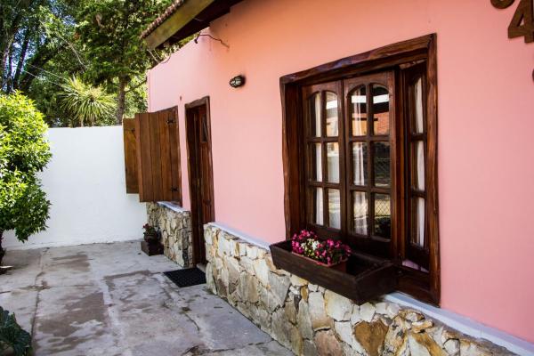 una casa rosa con una ventana y flores en el lateral en Particular en Villa Gesell