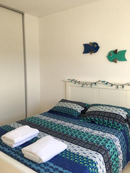 1 dormitorio con 2 camas y toallas. en Mareas del Golfo en Las Grutas