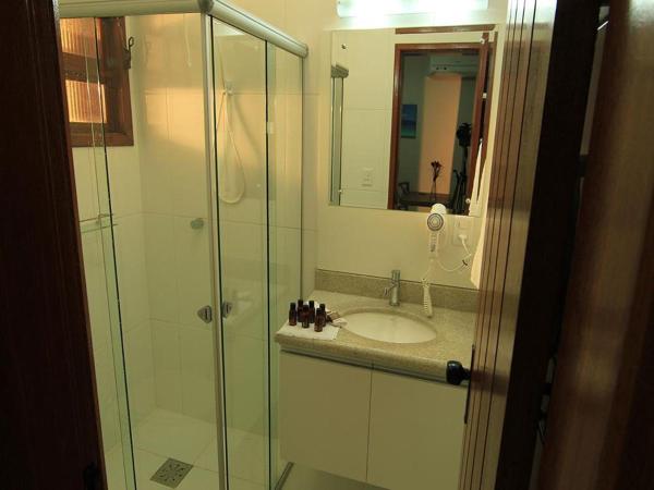 a bathroom with a sink and a glass shower at AP Beira da Lagoa da Conceição in Florianópolis