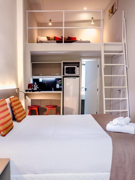Habitación pequeña con cama y cocina en Injoy Lofts Ipanema, en Río de Janeiro