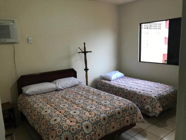 a bedroom with two beds and a cross on the wall at Casa 4 Quartos Praia dos Ingleses in Florianópolis