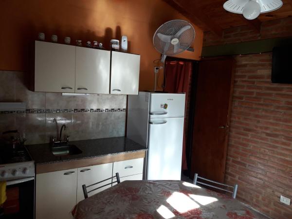 cocina con refrigerador blanca y mesa en Ariel Reynoso - Departamento Planta Alta, en Mina Clavero