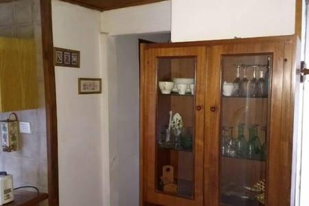 un armario de madera en una cocina con gafas. en Tu Cabaña en San Martín de los Andes