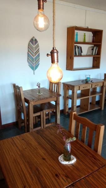 comedor con mesa de madera y sillas en Hotel Barracuda en Villa Gesell