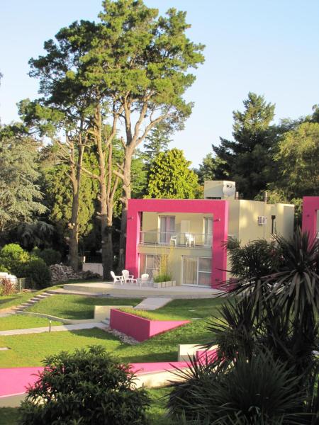 una casa rosa en medio de un jardín en Hotel Sierra de los Padres en Sierra de los Padres