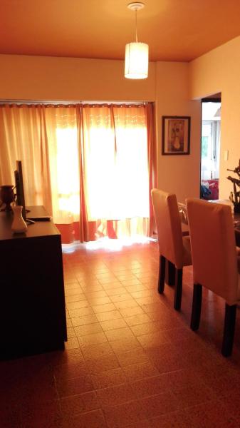 una sala de estar con mesa y sillas y una ventana en el Edificio Familiar Mar Veo de Villa Gesell