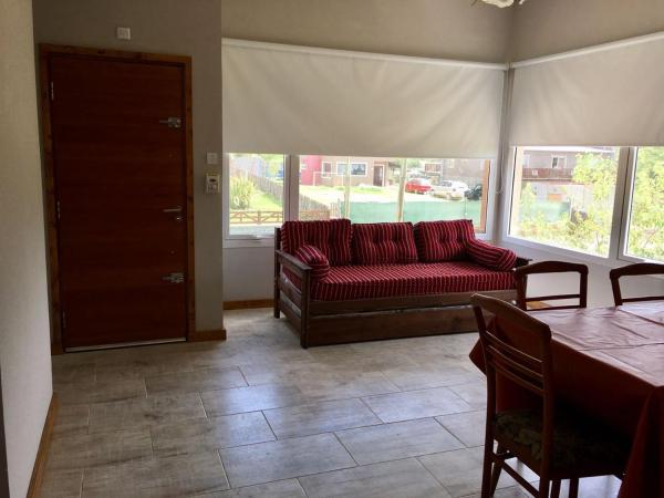 sala de estar con sofá rojo y mesa en Complejo Rafina Villa Gesell en Villa Gesell