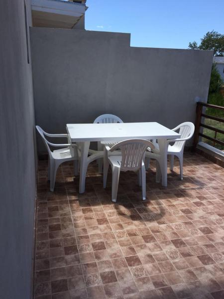 una mesa blanca y sillas en un patio en Complejo Rafina Villa Gesell en Villa Gesell