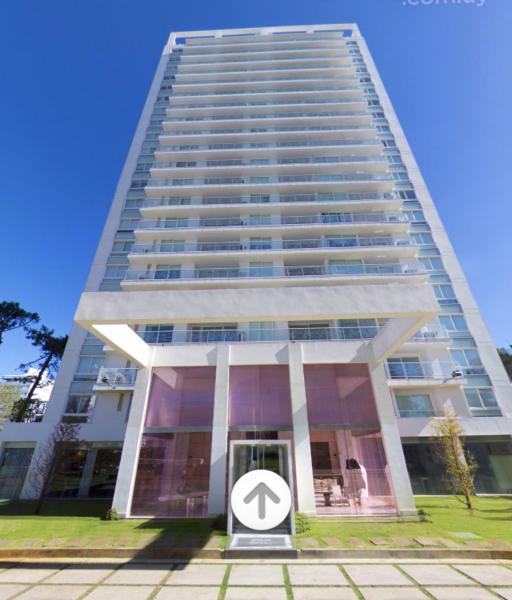 un edificio alto con un cartel delante en Yoo Punta del Este, en Punta del Este