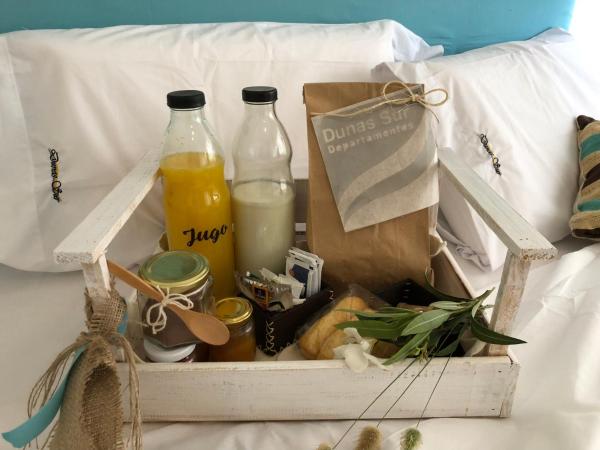 una caja con dos botellas de leche y una bolsa de zumo de naranja en Dunes Sur en Villa Gesell