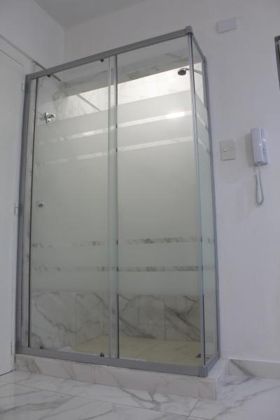una puerta de ducha de cristal en una habitación con pared en Calle Corrientes 1642 en Buenos Aires