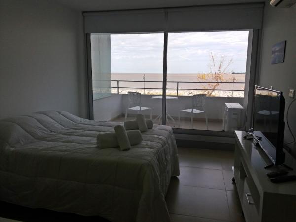 1 dormitorio con cama y vistas al océano en Dos Orillas, Monoambiente 204, en Colonia del Sacramento