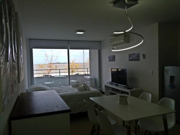 Habitación con cama, mesa y ventana en Dos Orillas, Monoambiente 204, en Colonia del Sacramento