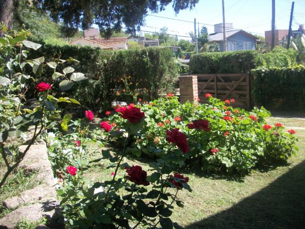 un jardín con rosas rojas en un patio en Cabañas Tio Willy, en Villa Carlos Paz