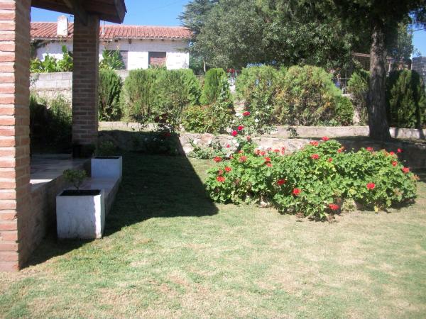 un jardín con flores y un banco en el césped en Cabañas Tio Willy, en Villa Carlos Paz