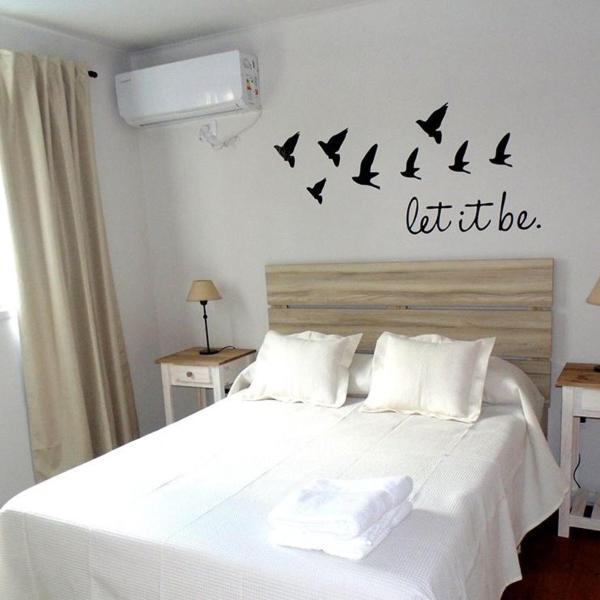 1 dormitorio con 1 cama con pájaros en la pared en Vista al Parque en Tandil