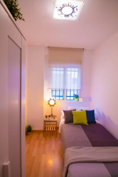 1 dormitorio con 2 camas y ventana en Utopia Home Alameda, en Sevilla