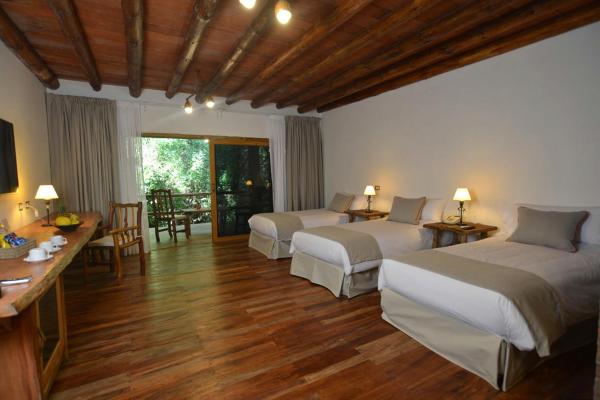 1 dormitorio con 2 camas, mesa y sillas en La Aldea De La Selva Lodge en Puerto Iguazú