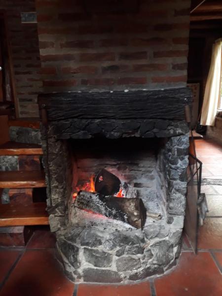 Una chimenea de ladrillo con fuego.  en Cabana La Maga, en Mar Blava