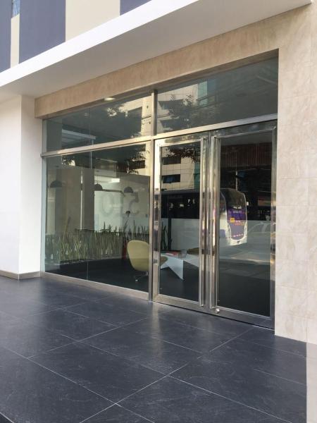 un edificio con puertas de cristal con reflejo de un autobús en Eduardo Designer Apartments Miraflores, en Lima