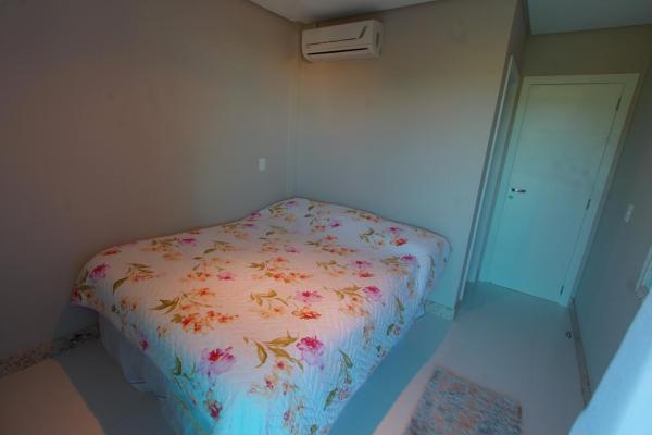 Un pequeño dormitorio con una cama con flores. en Villa das Ondas - Mariscal, en Bombinhas