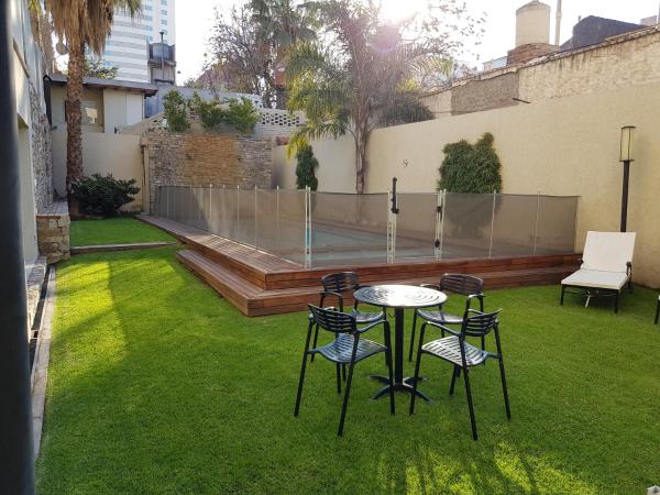 un patio con mesa y sillas en el césped en Apartamentos Centricos en Mendoza