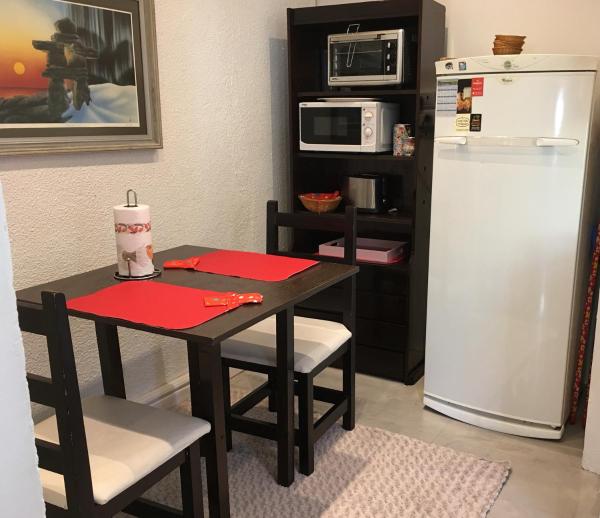 una pequeña cocina con mesa y refrigerador en You & Me Apartment en Tandil