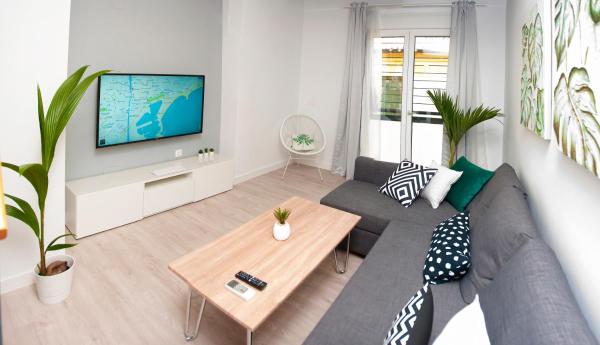 sala de estar con sofá y TV en Loft Duplex Malaga, en Málaga