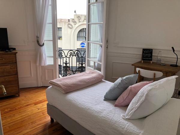 1 dormitorio con 1 cama con almohadas rosas y blancas en BAires Boutique Rooms en Buenos Aires
