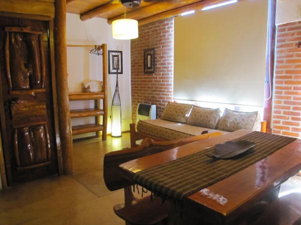 una sala de estar con un sofá y una mesa en Loma Escondida Apart Cabañas & Spa en Villa Gesell