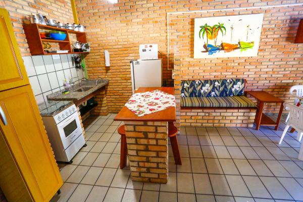 a small kitchen with a table and a refrigerator at Cabanas Jurerê in Florianópolis