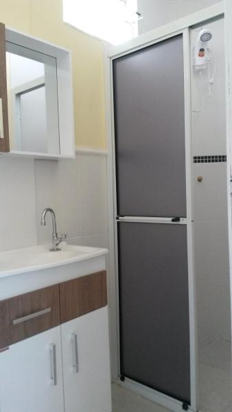 una refrigerador negra en una cocina junto a un fregadero en Suítesmariscal Suítes Mariscal, en Bombinhas