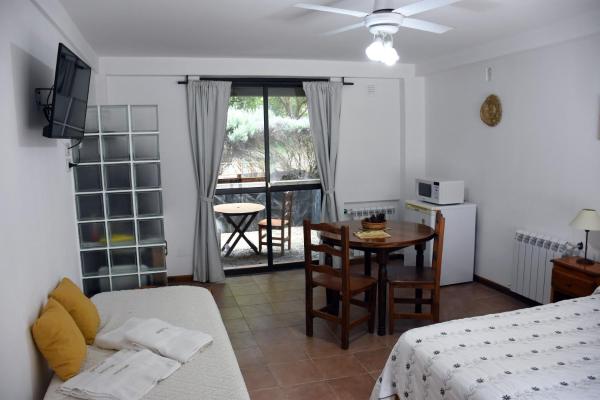 sala de estar con cama, mesa y cocina en Cabañas Antu Kuyen en Las Gaviotas